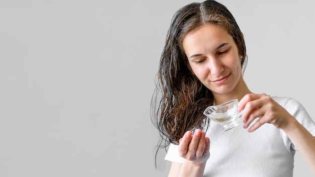 Copy-space vrouw met serum voor haar