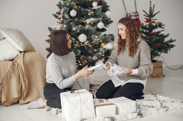 Coronavirus en kerstconcept. Vrouwen thuis. Dame in een grijze trui.