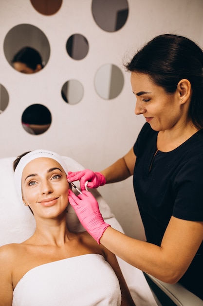 Cosmetologist die injecties op een gezicht van een vrouw in een schoonheidssalon maakt