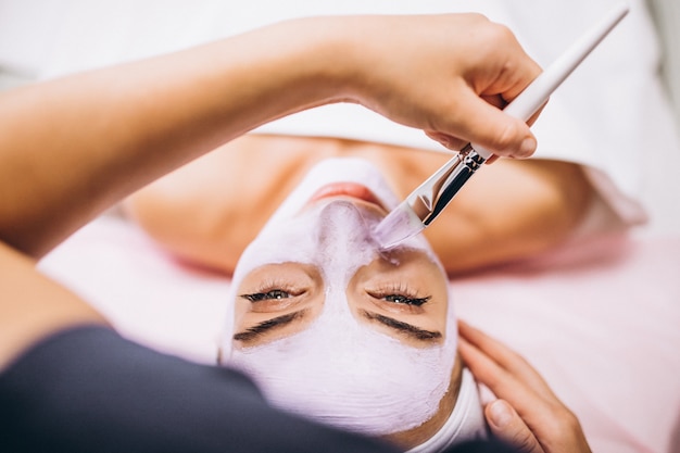 Gratis foto cosmetologist die masker op een gezicht van cliënt toepast in een schoonheidssalon