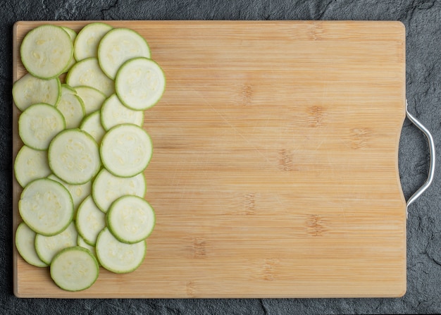 Courgette en plakjes in houten bord op zwarte achtergrond. Hoge kwaliteit foto