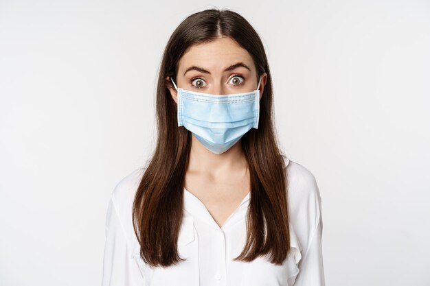 Covid en pandemisch concept jonge kantoorvrouw die een medisch masker draagt tijdens de sociale afstand van het coronavirus...