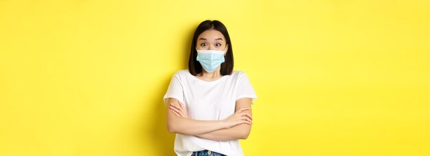 Covid-gezondheidszorg en pandemisch concept aziatische vrouw in witte t-shirt en medisch masker kruisarmen op ch