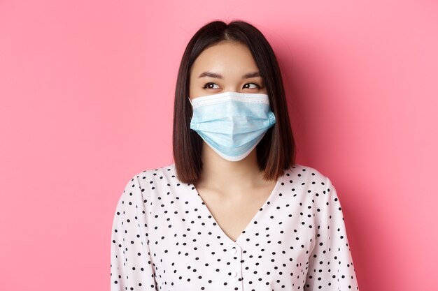 Covid pandemie en lifestyle concept mooi Aziatisch vrouwelijk model in medisch masker lachend lachend een...