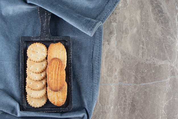 Cracker en zandkoekjes een bord op een handdoek, op het marmer.