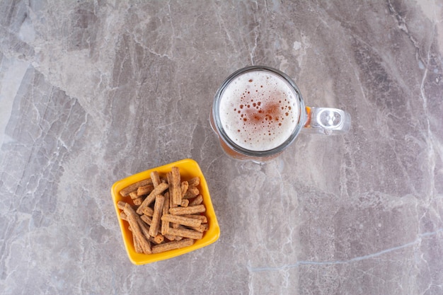 Crackers en glas koud bier op marmeren oppervlak