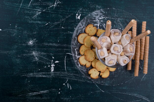 Crackers en wafelstokken met Turkse lokum in een glazen schotel, bovenaanzicht