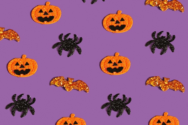 Creatief paars patroon gemaakt van pompoen, vleermuis en spinnen. halloween-concept plat plat, bovenaanzicht, kopieer ruimte