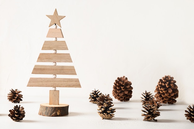 Creatieve houten eco kerstboom en dennenappels op witte achtergrond diy Premium Foto