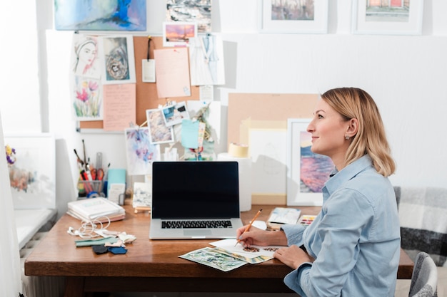 Gratis foto creatieve kunstenaar zit aan bureau