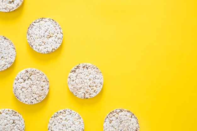 Creatieve lay-out gemaakt van rijstwafels op de gele achtergrond plat gelegd