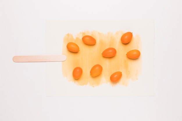Creatieve samenstelling van ijslolly van kumquat op stok