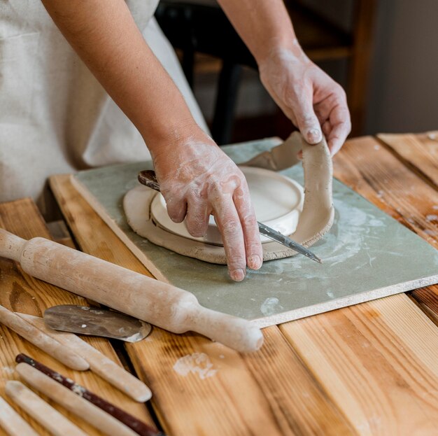Creatieve vrouw die een aarden pot maakt in haar atelier