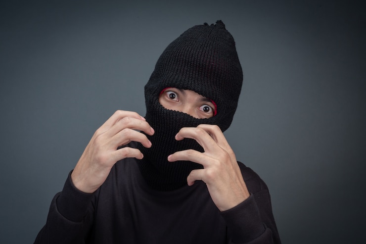 Gratis Foto criminelen dragen een masker in zwart op grijs