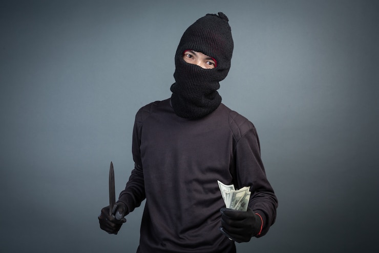 Gratis Foto criminelen dragen een zwart masker en houden donker op grijs
