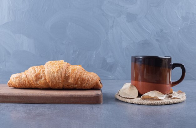 Croissant met koffie. Franse croissant op een houten bord en kopje espresso.