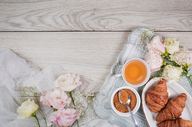 Gratis foto croissants en bloemen in plat leggen