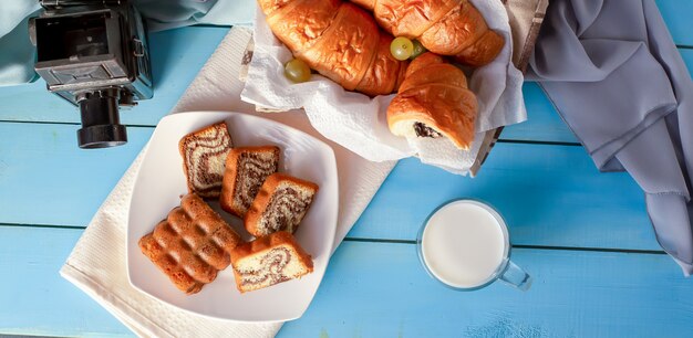 Croissants met chocoladeroom en een glas melk op de blauwe lijst. Bovenaanzicht