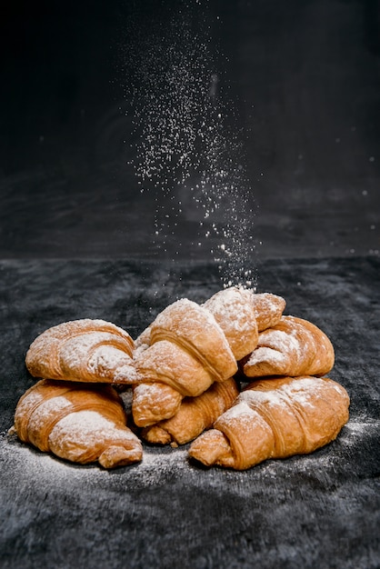 croissants met poedersuiker op grijze tafel.