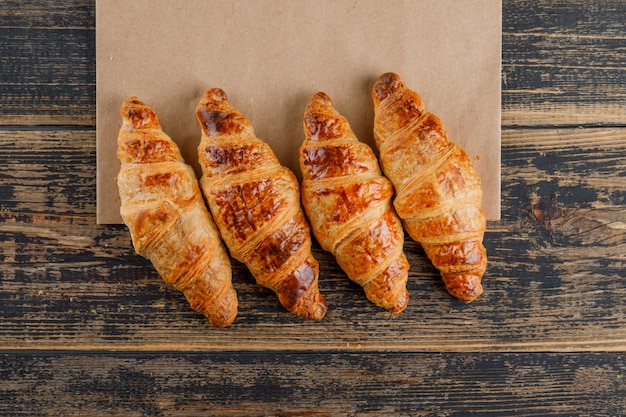 Croissants op houten en papieren zak. plat lag.