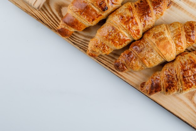 Croissants op witte en houten tafel. plat lag.