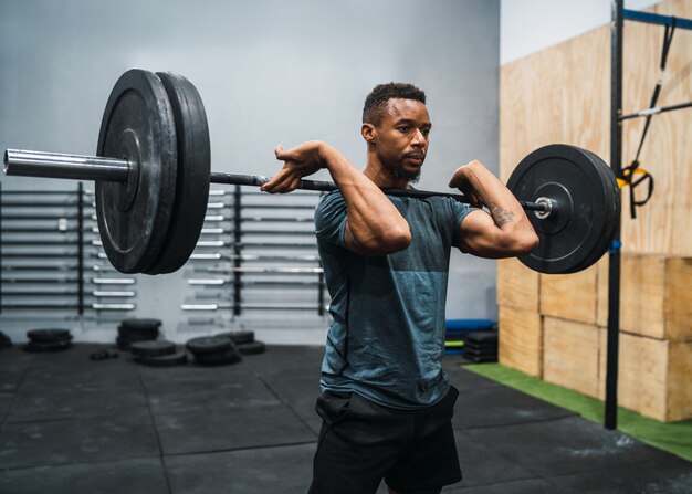 Crossfitatleet die oefening met een barbell doen.