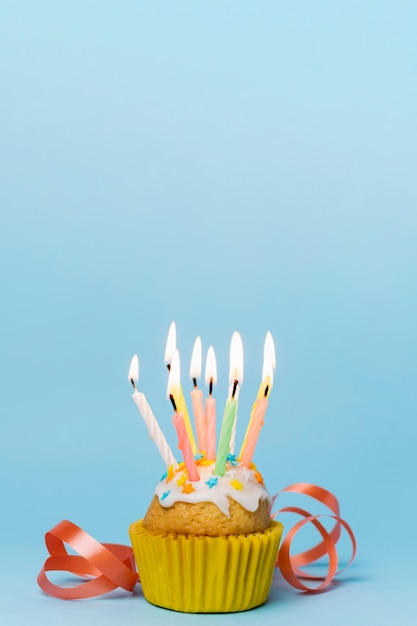 Cupcake met aangestoken kaarsen en lint