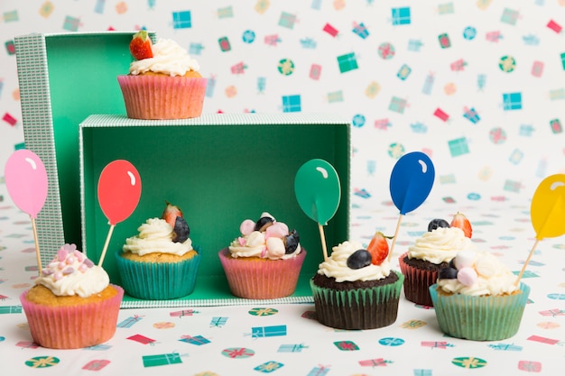 Cupcakes met heldere ballonbovenste laagjes op lijst