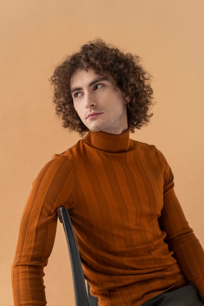 Gratis foto curly haired man met bruine blouse poseren