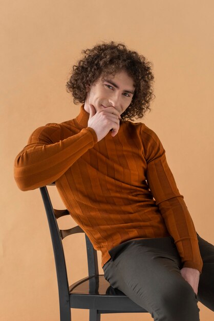 Curly haired man met bruine blouse poseren