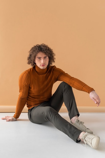 Curly haired man met bruine blouse poseren