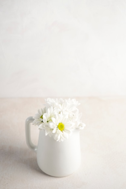 Daisy bloemen in kruik op tafel