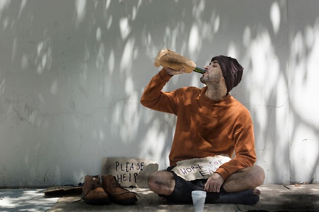 Dakloze man die alcoholische drank drinkt