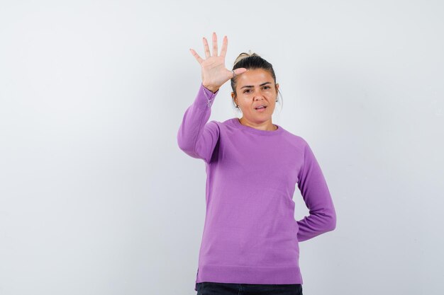 Dame die vijf vingers in wollen blouse laat zien en er zelfverzekerd uitziet