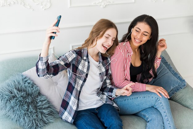 Dames lachen en luisteren naar muziek