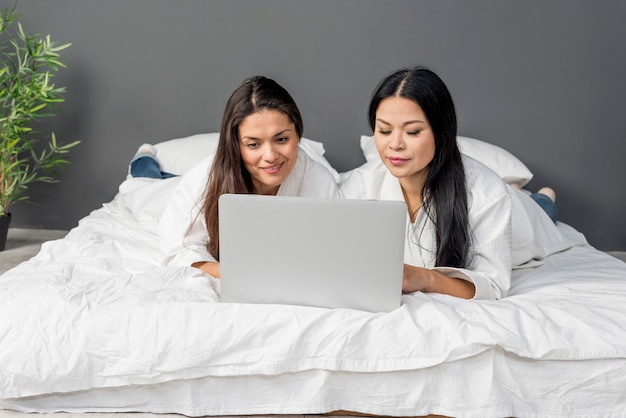 Dames op bed met behulp van laptop