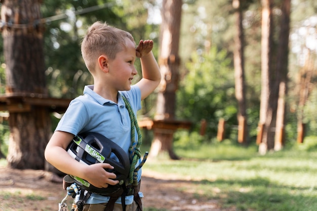 Gratis foto dappere jongen die plezier heeft in een avonturenpark