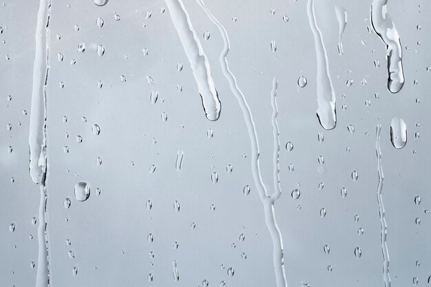 De achtergrond van de watertextuur, regenachtig venster op bewolkte dag