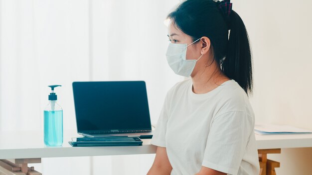 De Aziatische vrouw die de hand van het het desinfecterende middelwas van de alcoholgel gebruiken vóór open tablet voor beschermt coronavirus. Vrouw duwt alcohol om schoon te maken voor hygiëne bij sociale afstand thuisblijven en zelfquarantainetijd