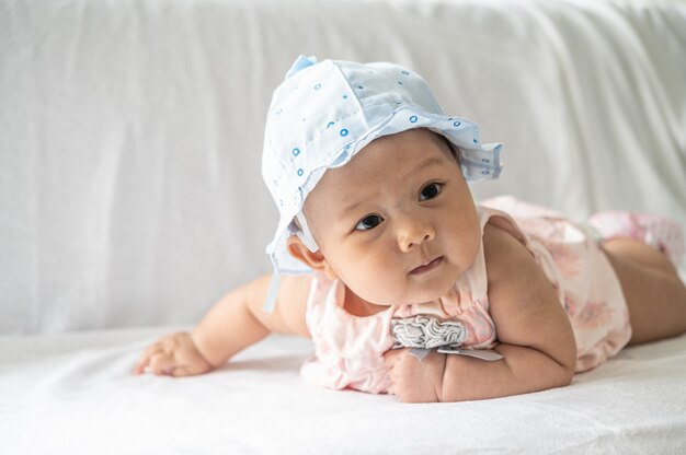 De baby ligt met zijn gezicht naar beneden op het bed.