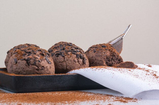 De ballen van het chocoladeschilferkoekje op een handdoek op een houten plaat, op het marmer.