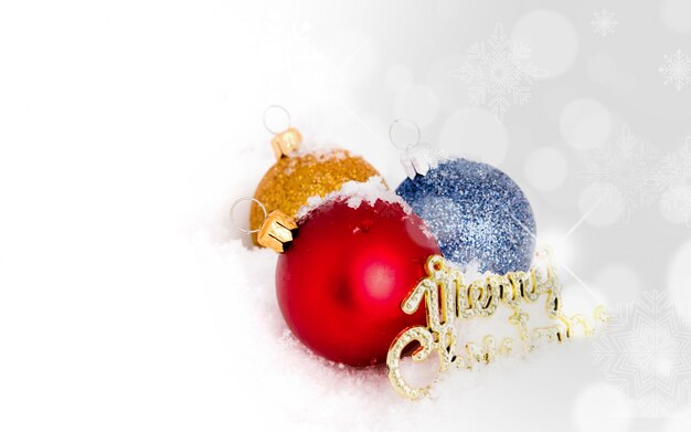 De ballen van Kerstmis met sneeuw en een vrolijk kerstfeest bericht