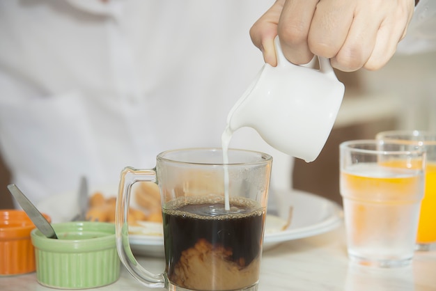 De bedrijfsmens eet het Amerikaanse die ontbijt in een hotel wordt geplaatst