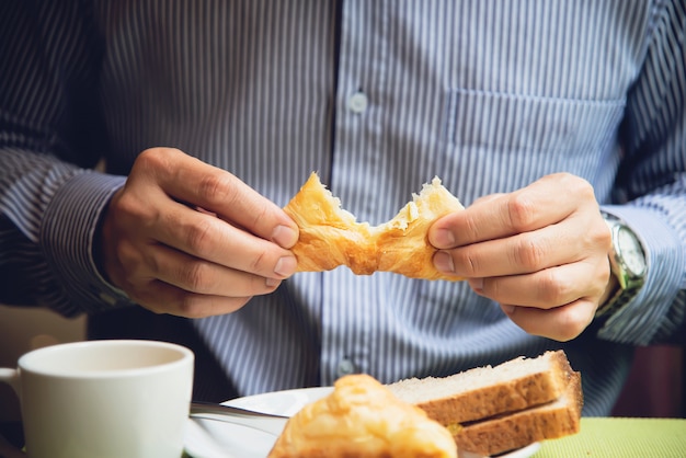 De bedrijfsmens eet het Amerikaanse ontbijt dat in een hotel wordt geplaatst