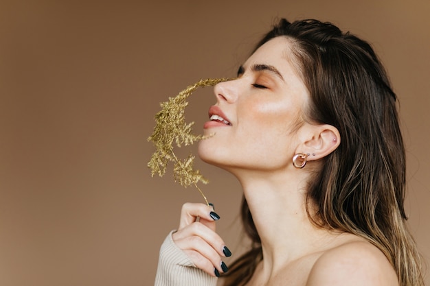 De bevallige bloem van de dameholding. Schattige blanke vrouw poseren met plant.