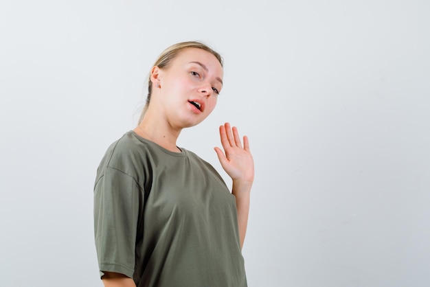 De blonde vrouw toont stopgebaar met hand op witte achtergrond