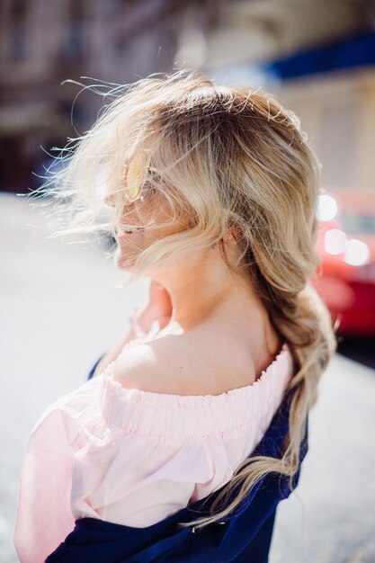 Gratis foto de blondevrouw in suglasses kijkt omhoog in een zonnige hemel