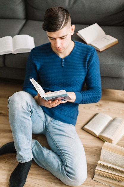 Gratis foto de boeken van de jonge mensenlezing op vloer