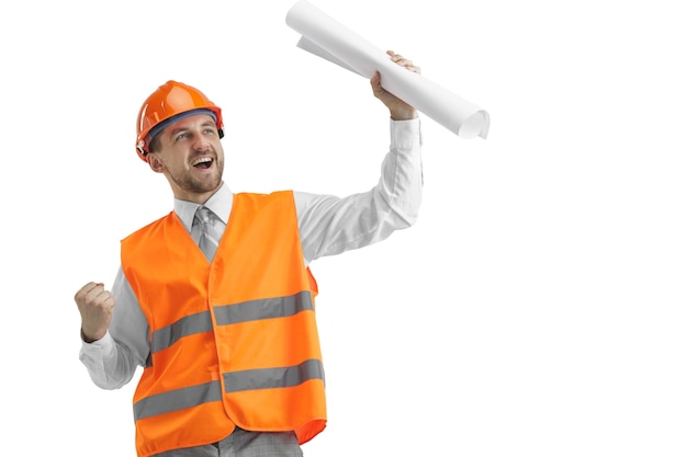 Gratis foto de bouwer in een bouwvest en een oranje helm die zich op witte muur bevindt. veiligheidsspecialist, ingenieur, industrie, architectuur, manager, beroep, zakenman, baanconcept