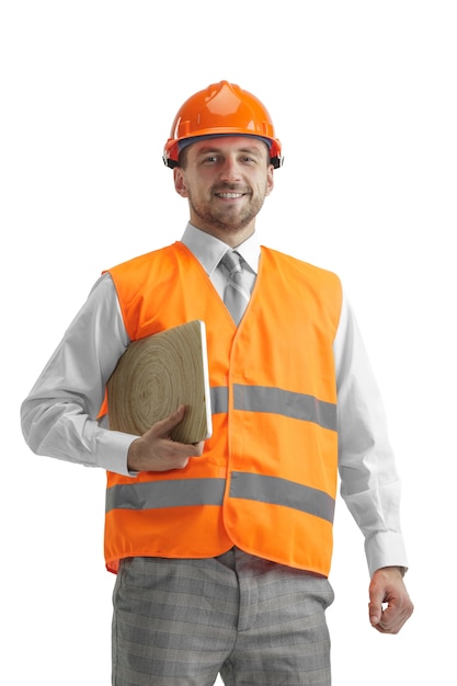 De bouwer in een bouwvest en een oranje helm met laptop.